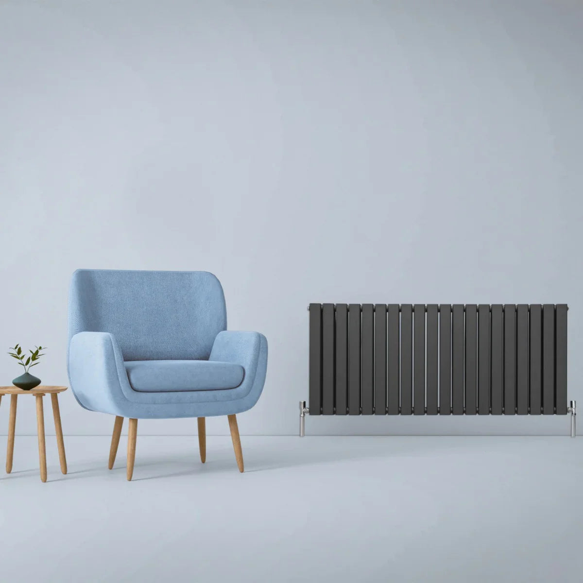Designer flat panel radiator in anthracite grey, 600mm x 1400mm, sleek vertical design beside a modern blue armchair and wooden table
