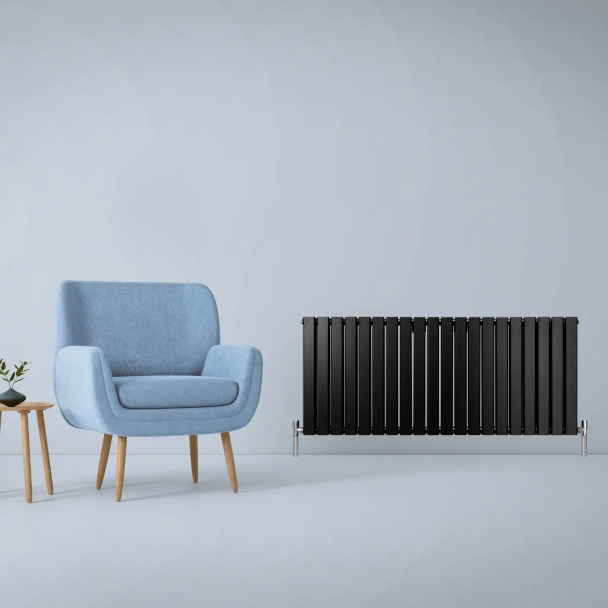 Matt black designer flat panel radiator, 600mm x 1400mm, sleek vertical slats, paired with a modern blue armchair and side table