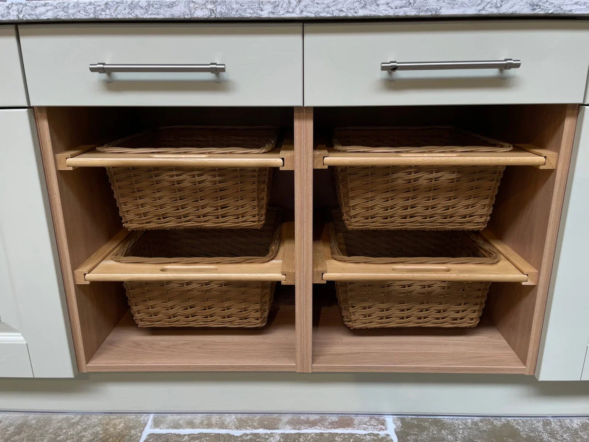 Three pull-out wicker kitchen baskets with natural wood trim, neatly arranged in a light-colored cabinet, showcasing their spacious design