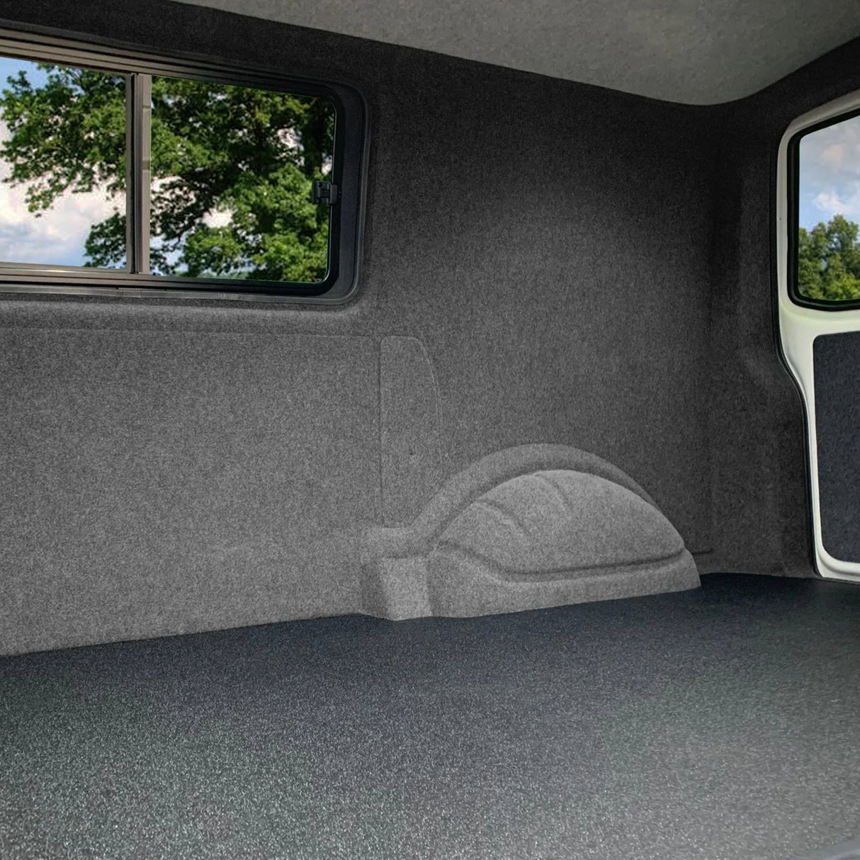Smoke grey van carpet lining with a smooth texture, covering the interior, featuring a contoured shape for a snug fit