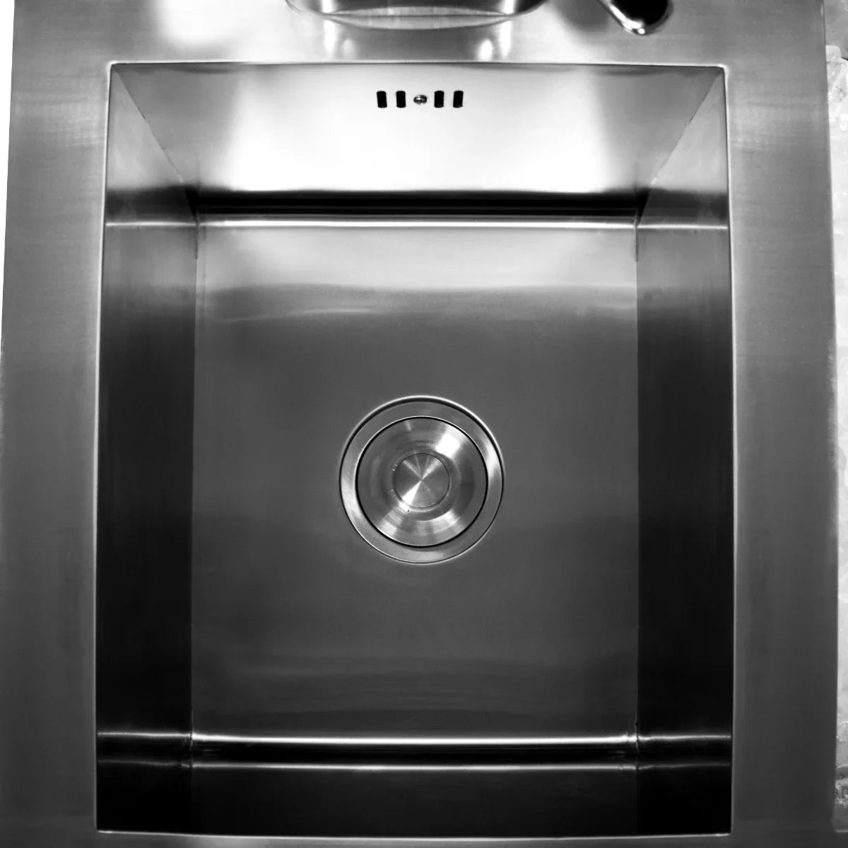 Stainless steel sink with a polished finish, featuring a circular drain and sleek, modern design for a cocktail bar station