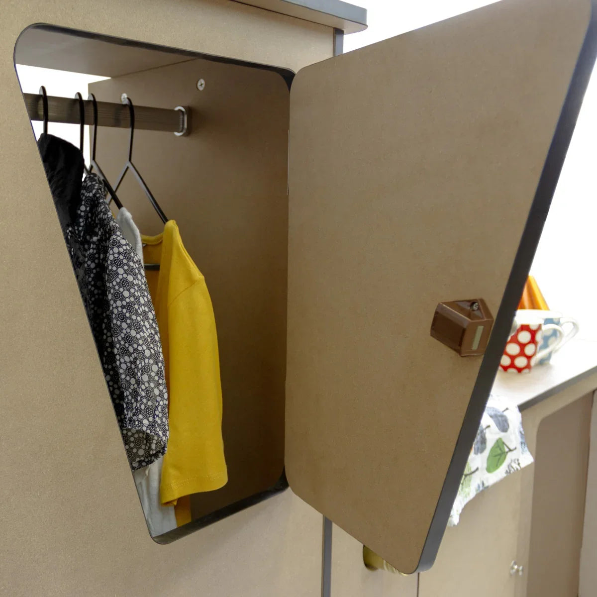 MDF Camper Van Kitchen Unit LHD with a triangular door, showcasing hanging clothes and a stylish, modern design in natural wood finish