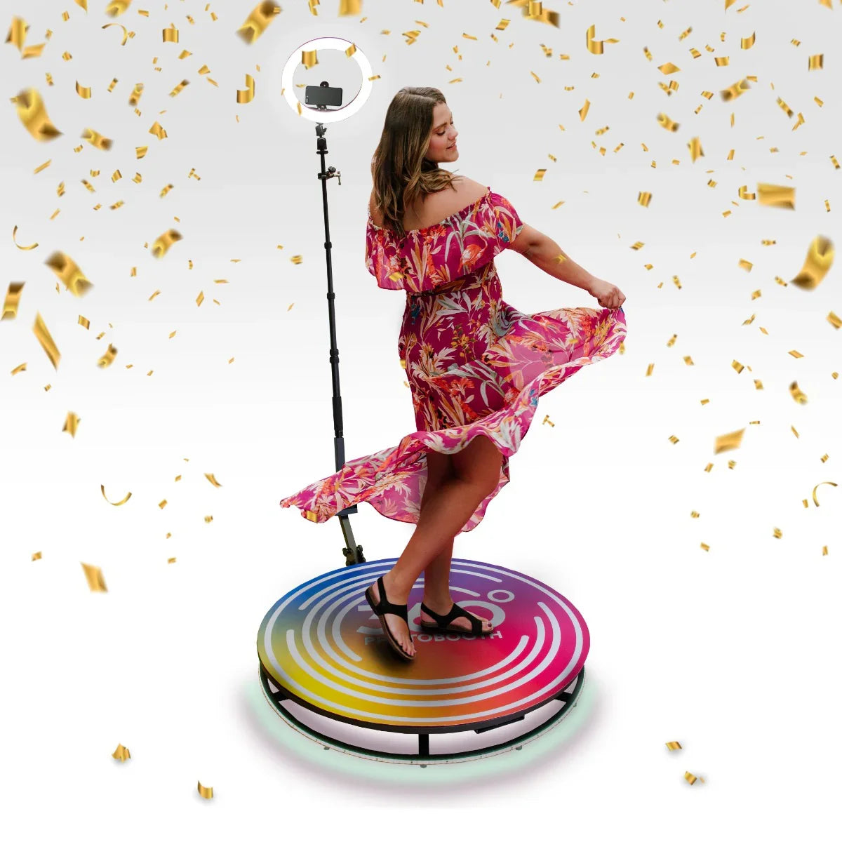 360 Photo Booth with colorful base, featuring a woman in a floral dress, surrounded by confetti and a ring light for vibrant photography