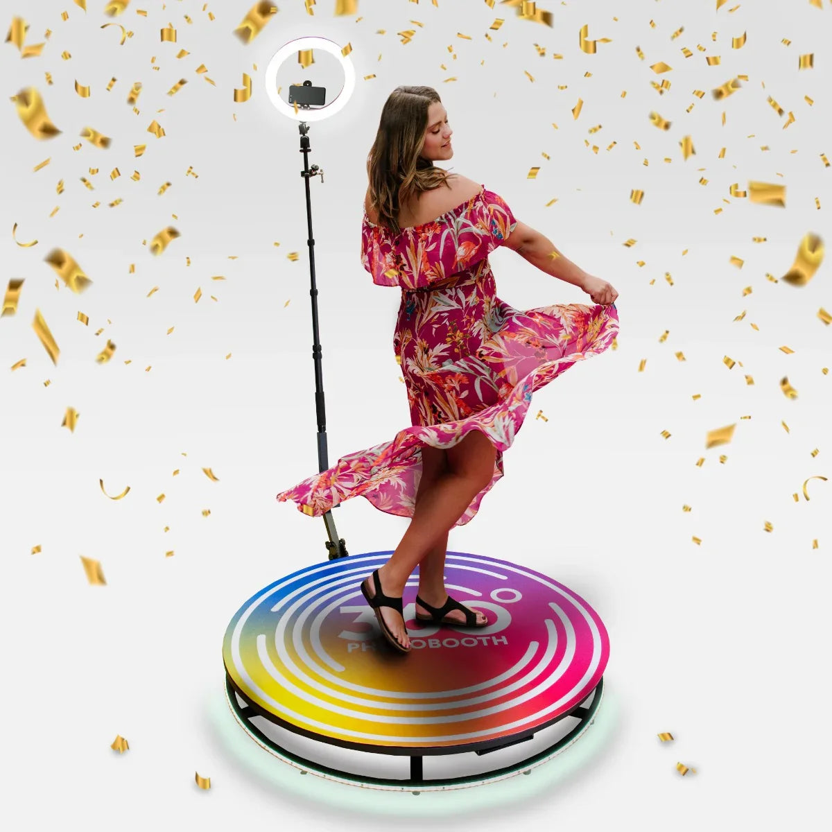 360 Photo Booth with colorful LED base, featuring a woman in a floral dress twirling, surrounded by golden confetti and a ring light