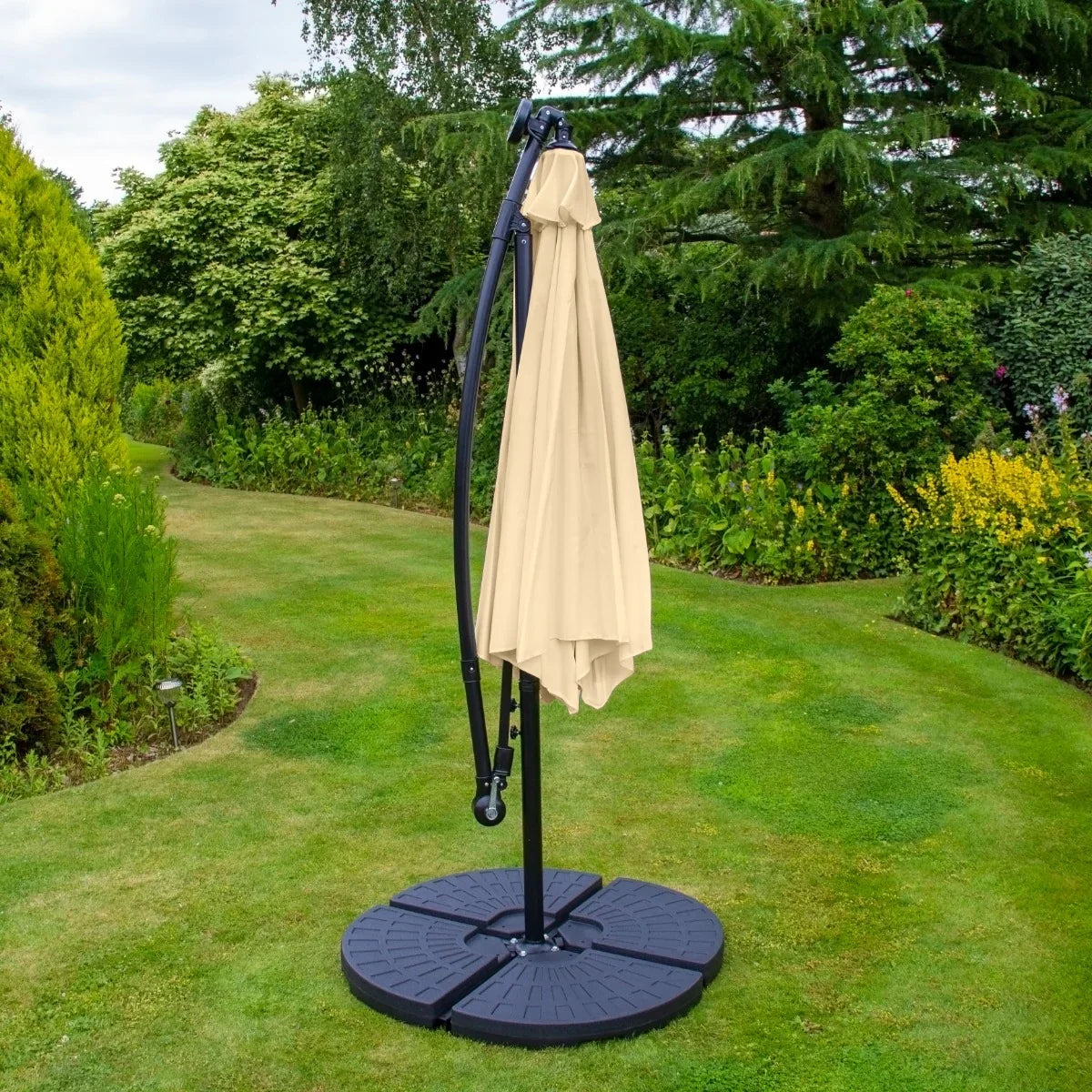 Beige 3m LED cantilever parasol with a sturdy fan base, set in a lush garden, featuring a curved arm and elegant fabric canopy