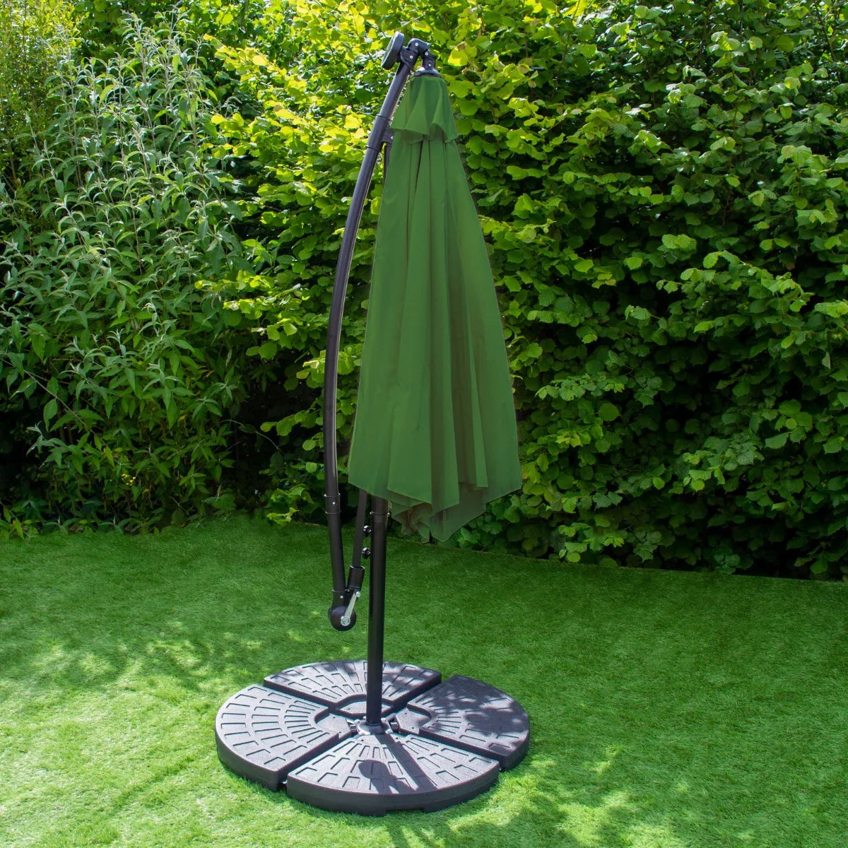 Green 3m LED cantilever parasol with a sturdy fan base, featuring a sleek design and a vibrant green canopy, set against lush greenery