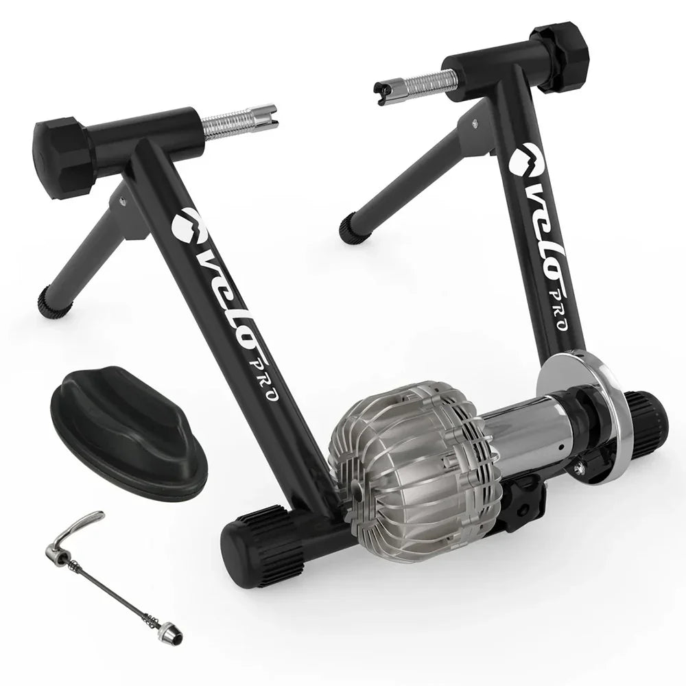 Black Velo Pro Fluid Turbo indoor bike trainer with a sleek black frame, silver resistance unit, and adjustable feet for stability