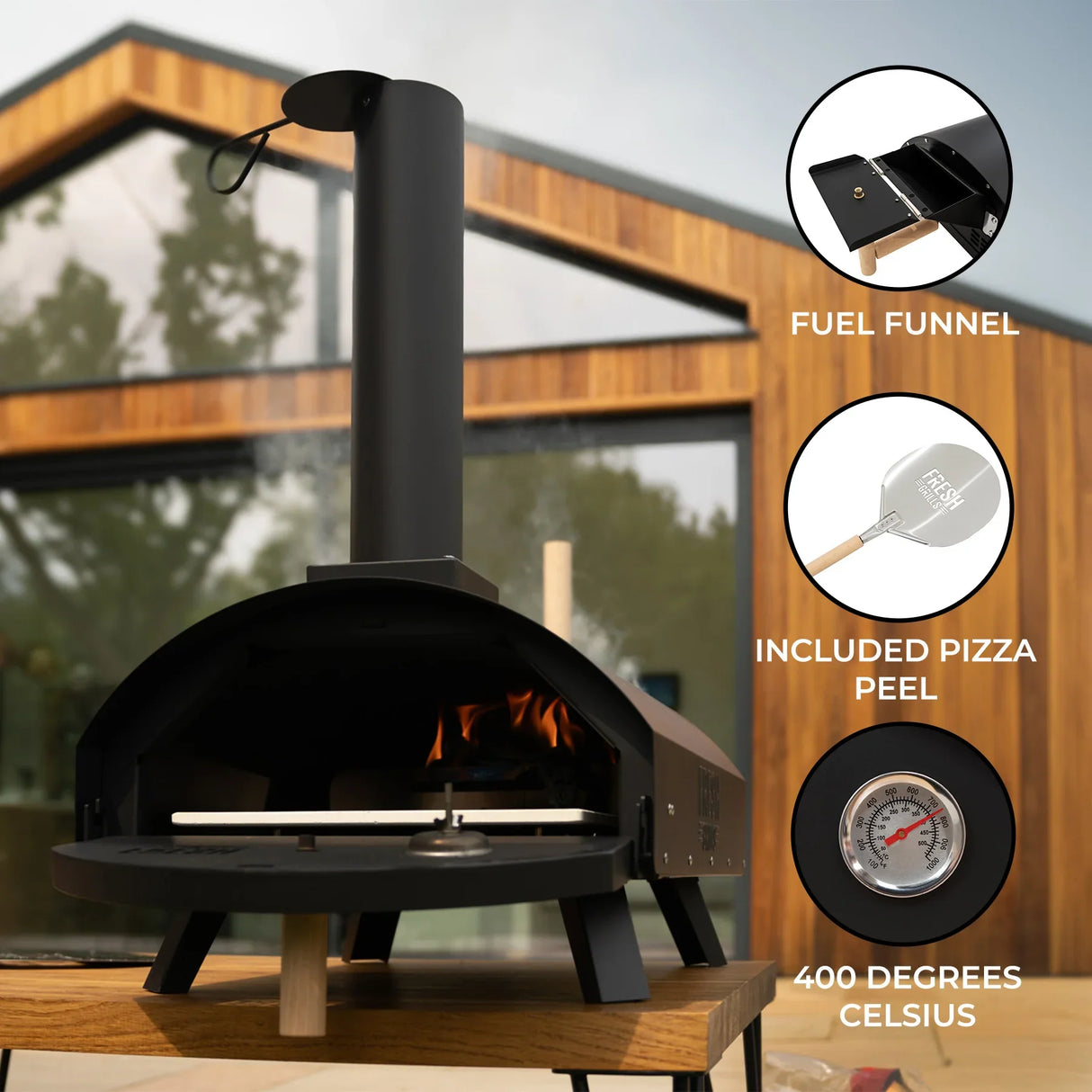 Classic outdoor pizza oven with a sleek black finish, chimney, wooden base, and included pizza peel, designed for high-temperature cooking