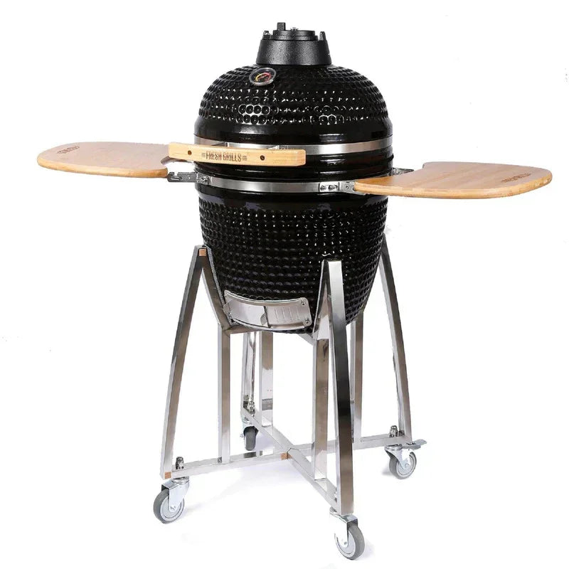 Black 21-inch Kamado charcoal BBQ grill with wooden side shelves, stainless steel frame, and wheels for easy mobility