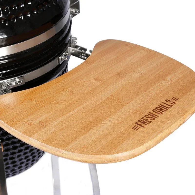 Fresh Grills Kamado Charcoal BBQ Grill 21" with a bamboo side shelf, featuring a sleek black finish and sturdy metal frame