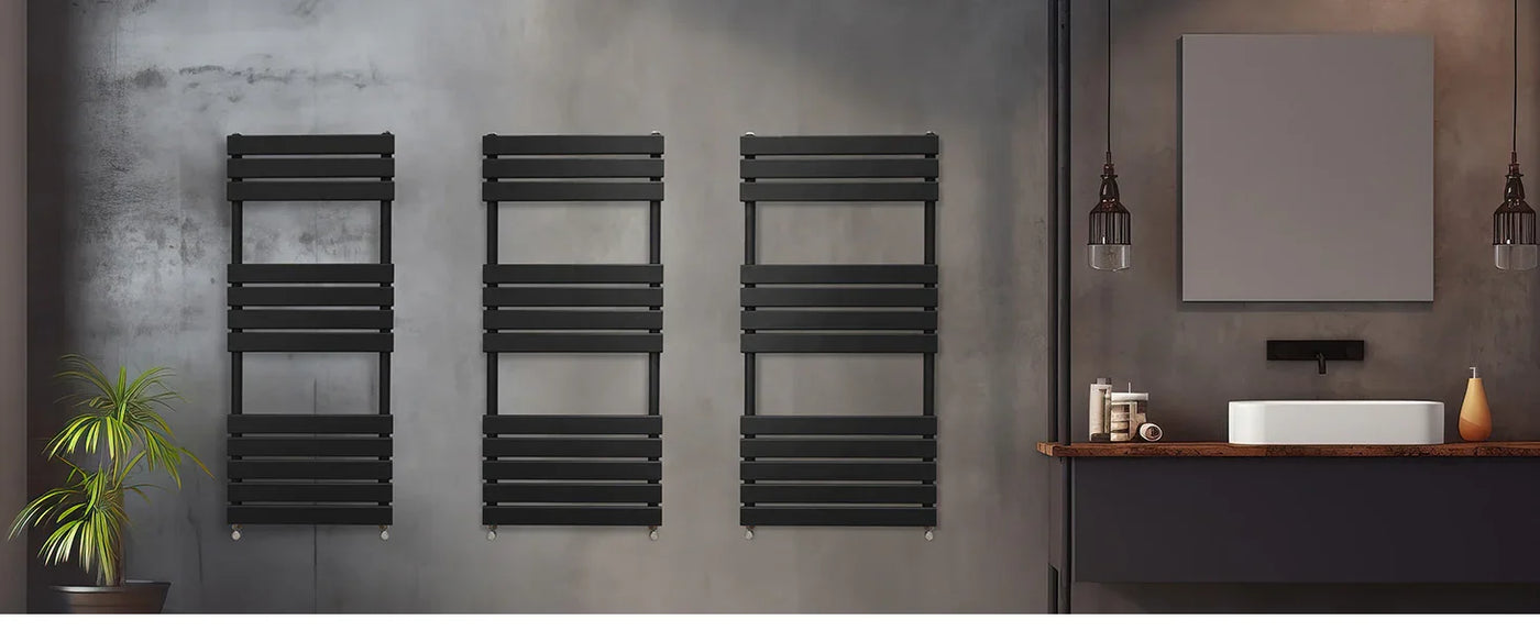 Sleek black towel radiators mounted on a textured gray wall, enhancing a modern bathroom with minimalist decor and warm lighting