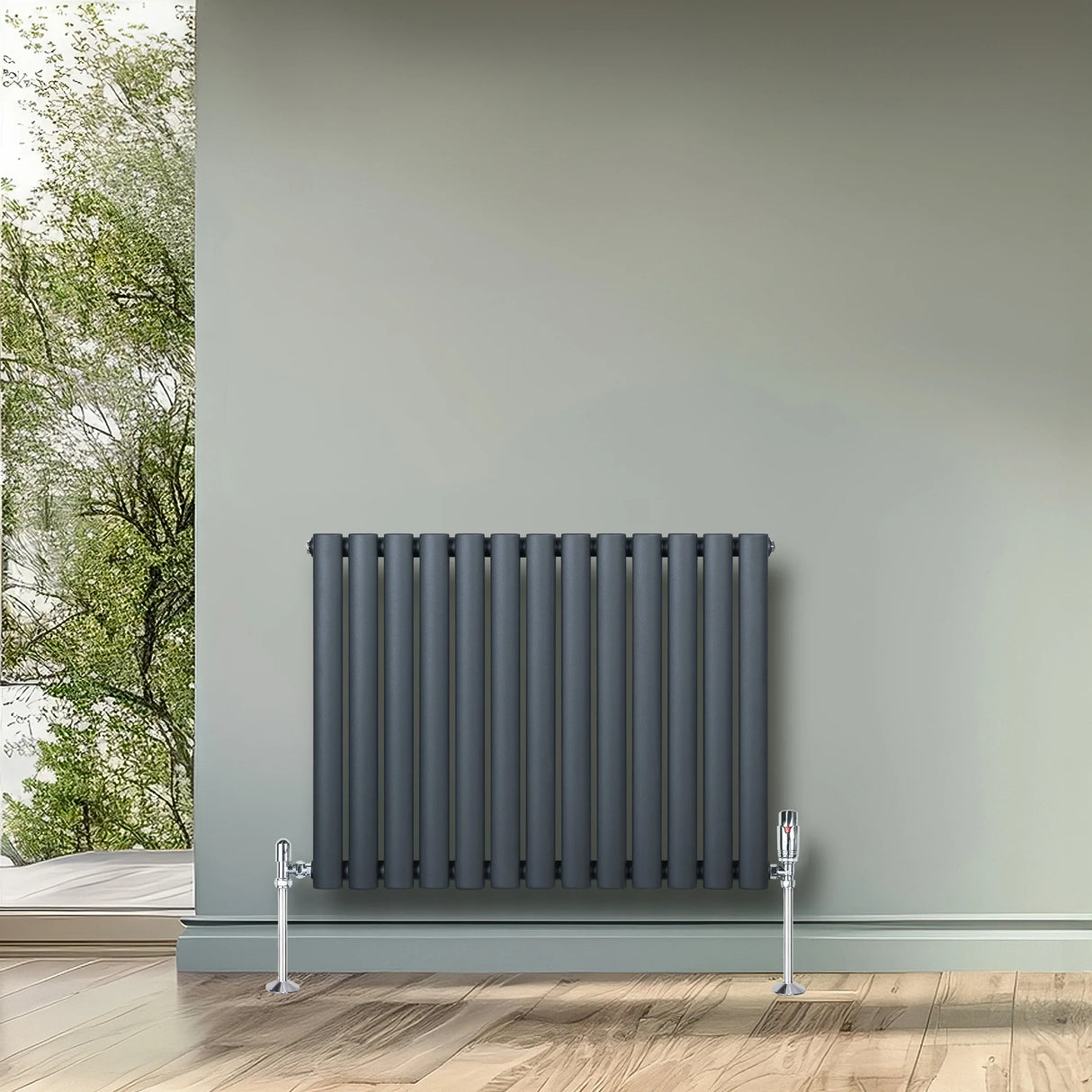 Oval single column radiator in anthracite grey, featuring vertical tubes and chrome valves, mounted on a light green wall