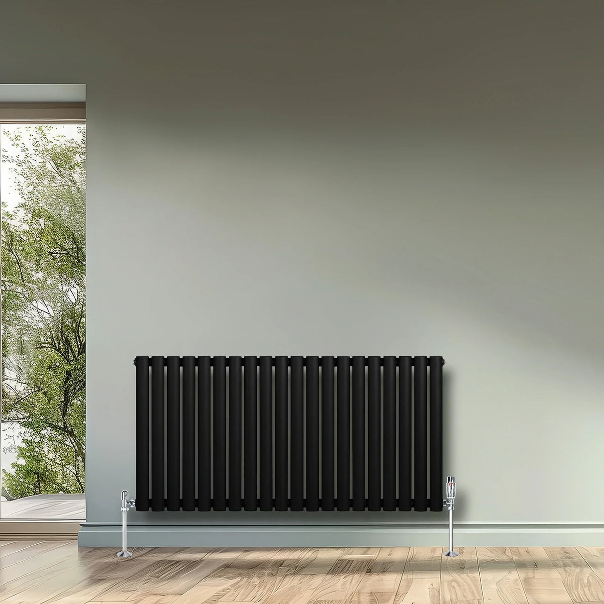 Sleek black oval single column radiator with chrome valves, mounted on a light wall, enhancing modern interior aesthetics