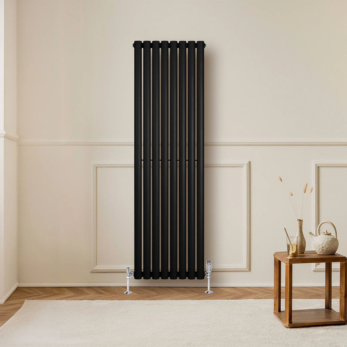 Sleek black oval single column radiator with chrome valves, standing tall against a neutral wall, enhancing modern interior decor