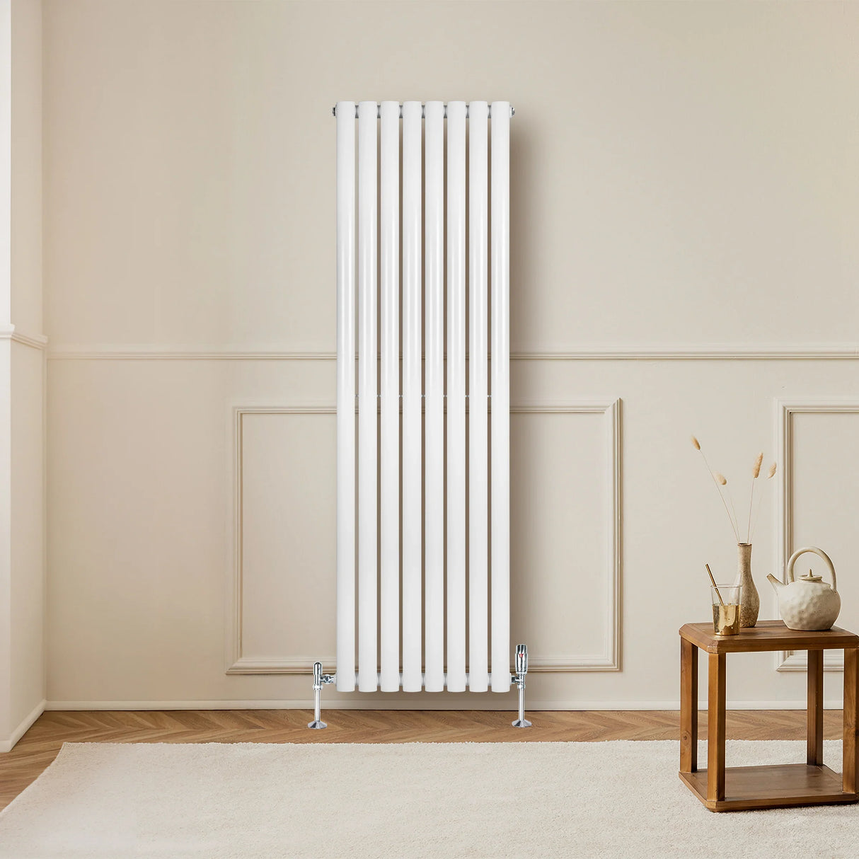 Sleek white oval single column radiator, 1600mm x 480mm, mounted on a wall in a cozy room with wooden flooring and decor