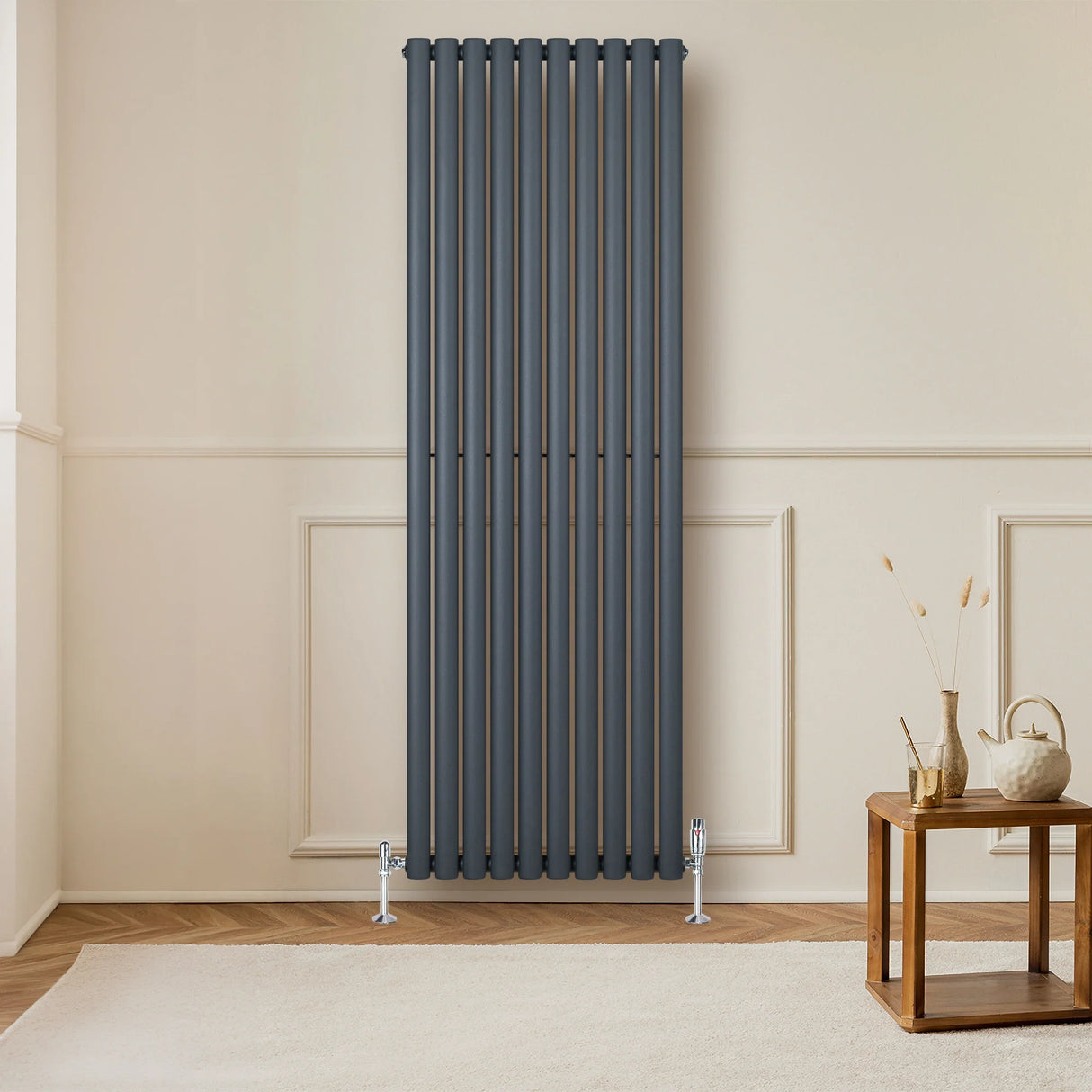 Anthracite grey oval single column radiator with vertical bars, mounted on a wall, enhancing a modern living room decor