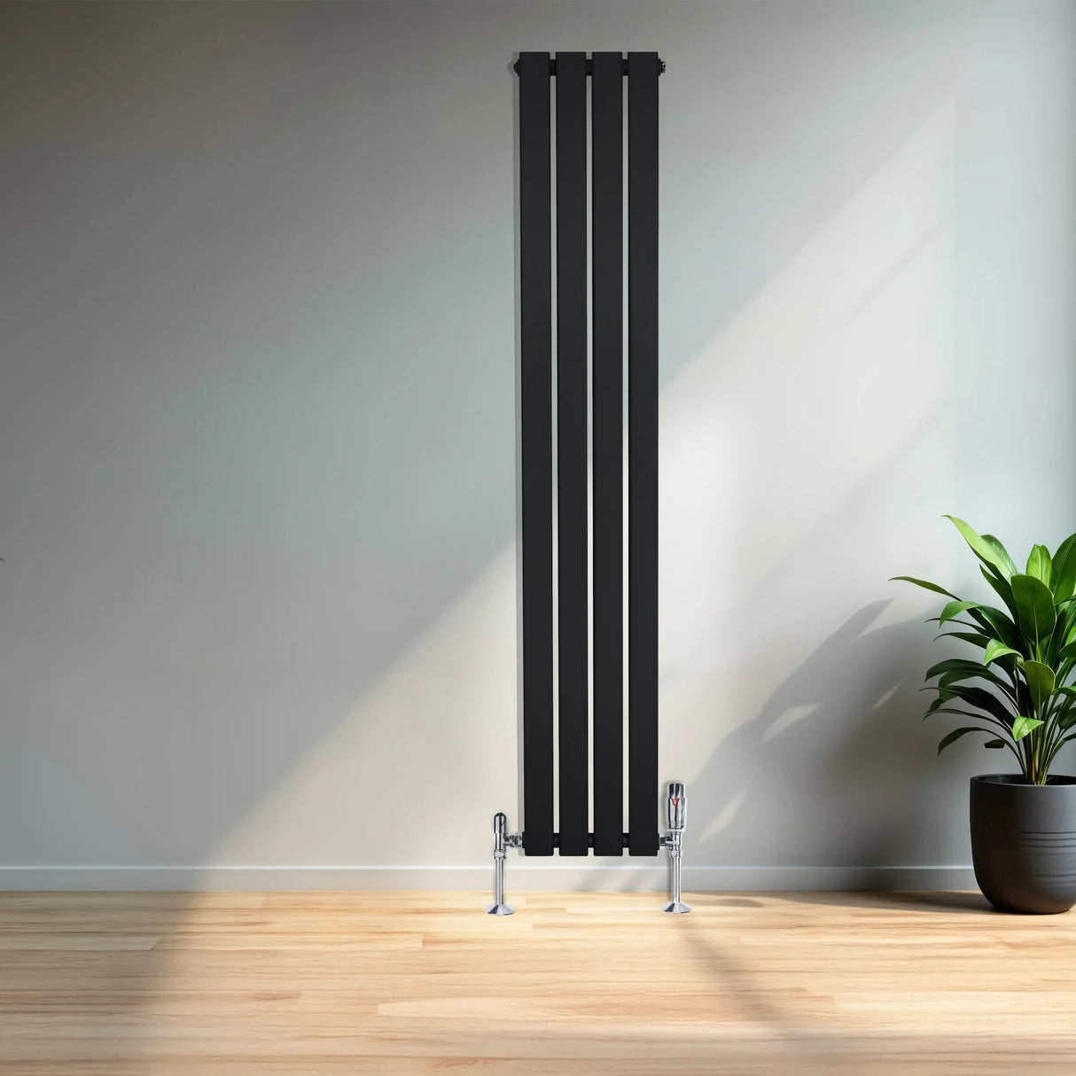 Sleek black flat single column radiator, 1600mm x 280mm, with chrome valves, positioned against a modern interior wall and wooden floor
