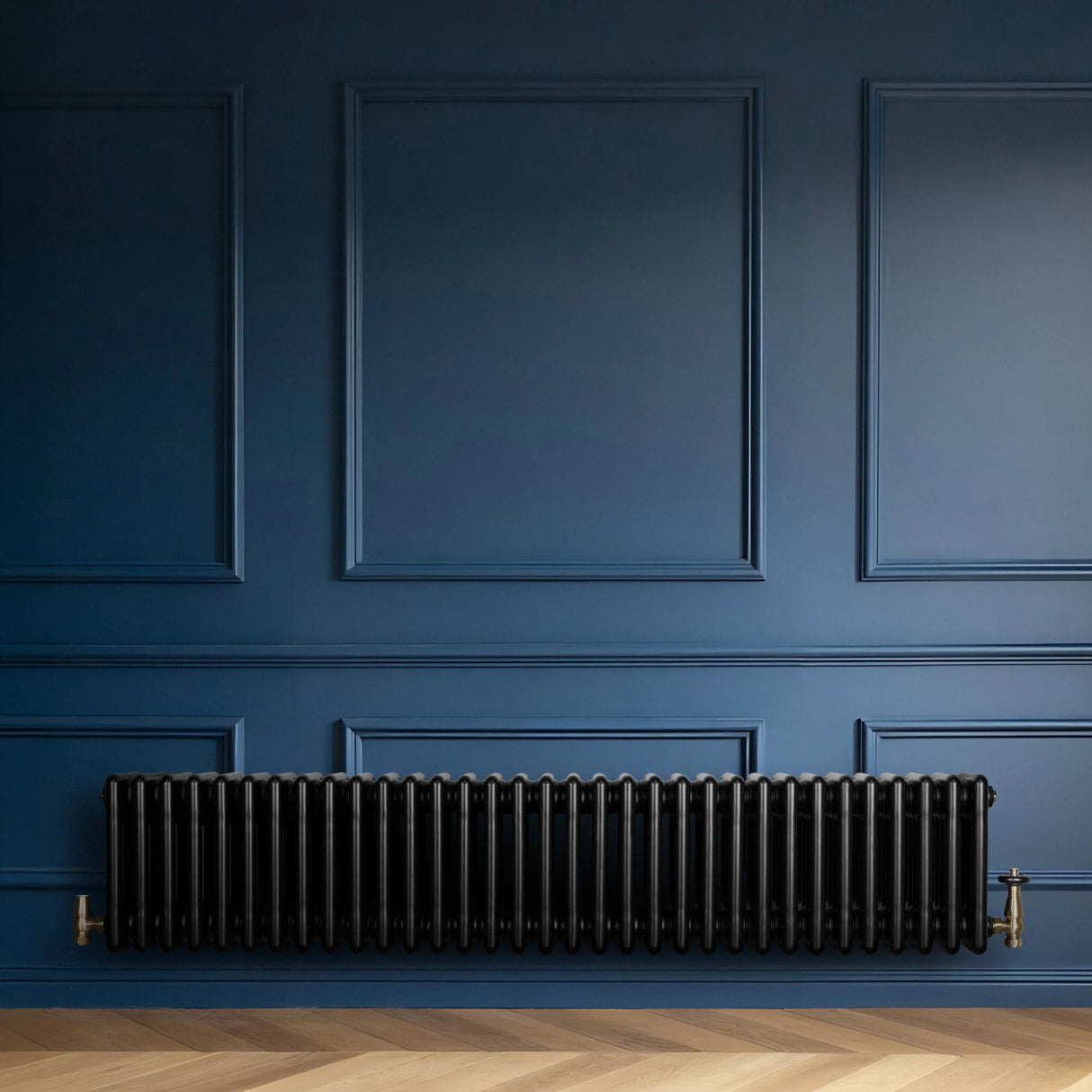 Traditional black 4 column radiator with brass valves, mounted against a deep blue wall, enhancing a classic interior design