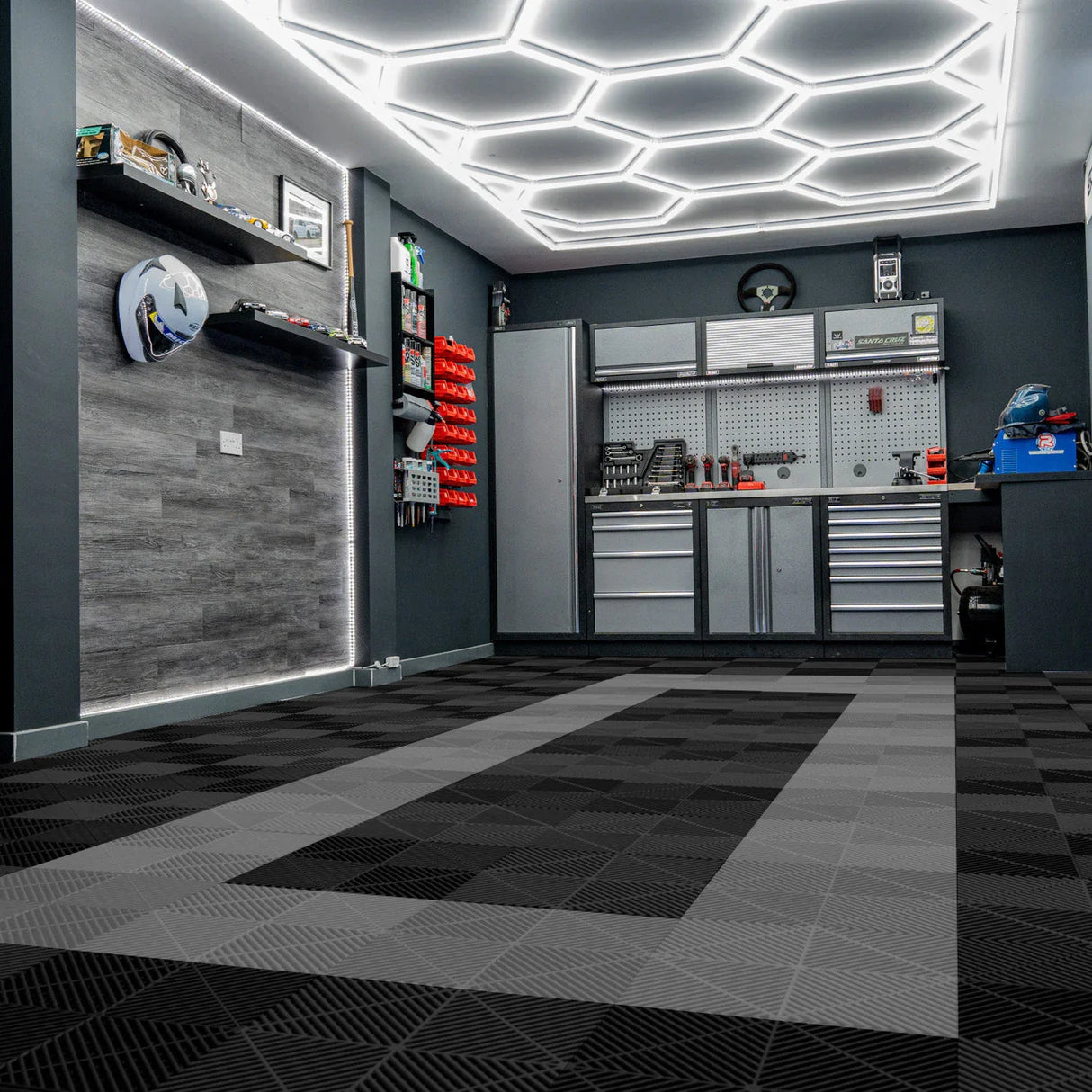Vented garage floor tiles in black and grey, featuring a sleek, textured design, arranged in a modern garage setting with bright lighting