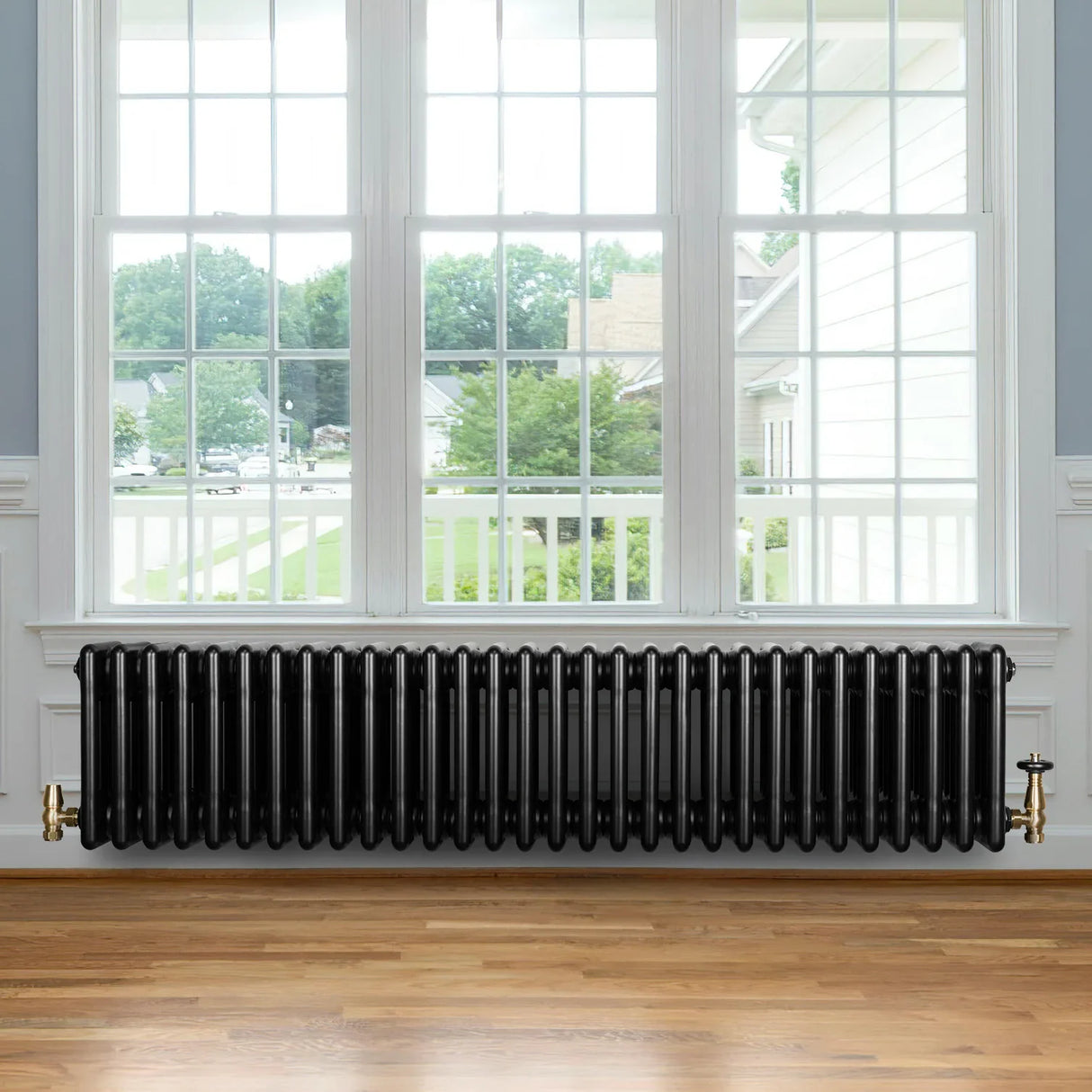 Traditional black 4 column radiator, 300 x 1370mm, featuring a sleek design, elegant finish, and brass valve, placed under a large window