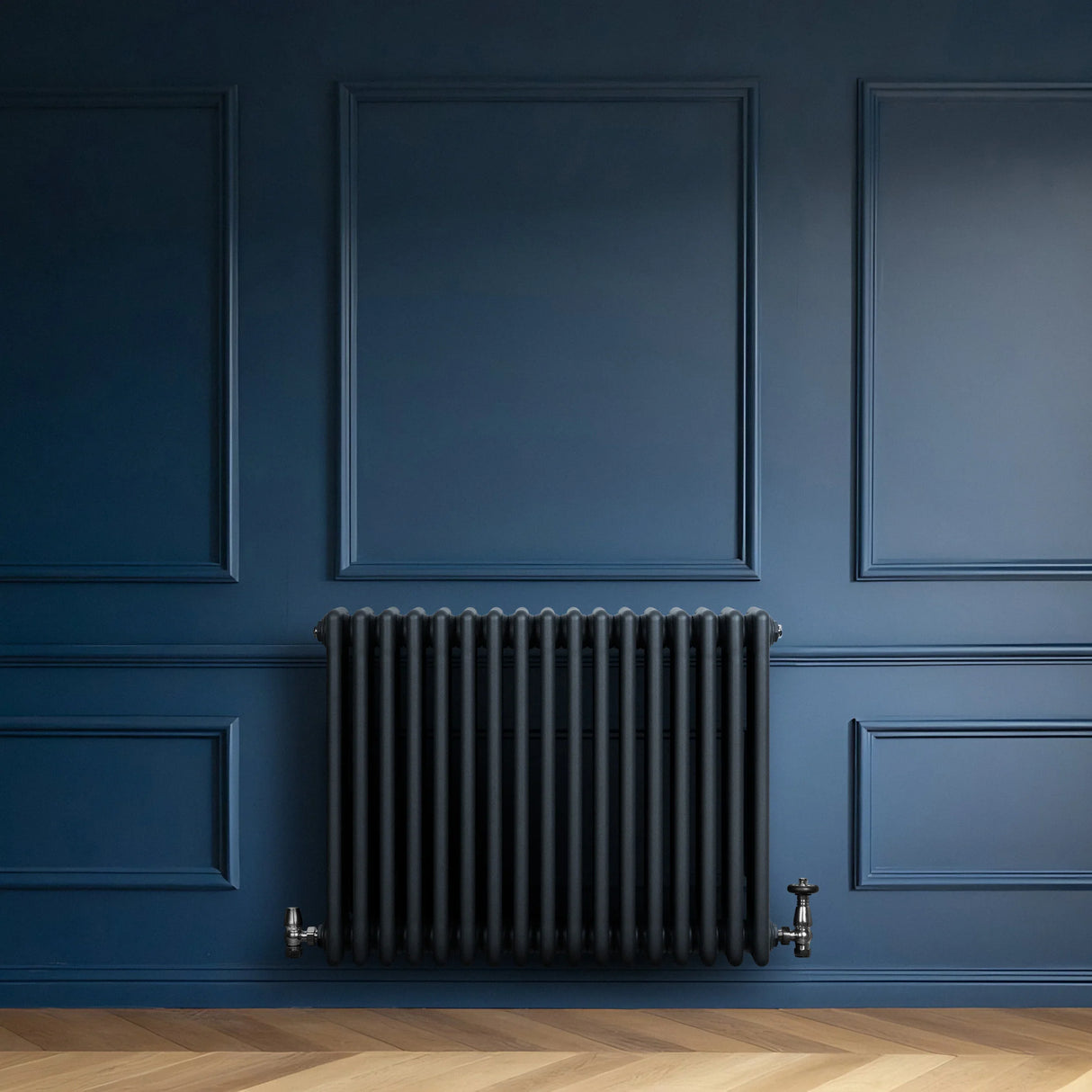 Traditional 4 column radiator in anthracite grey, featuring a sleek design with vertical tubes, mounted on a dark blue wall