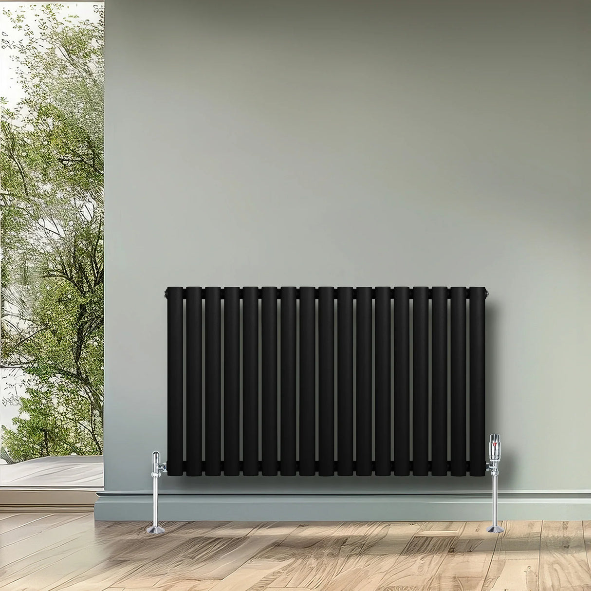 Sleek black oval single column radiator, 600 x 1020mm, mounted on a light wall, complementing a modern interior with wooden flooring