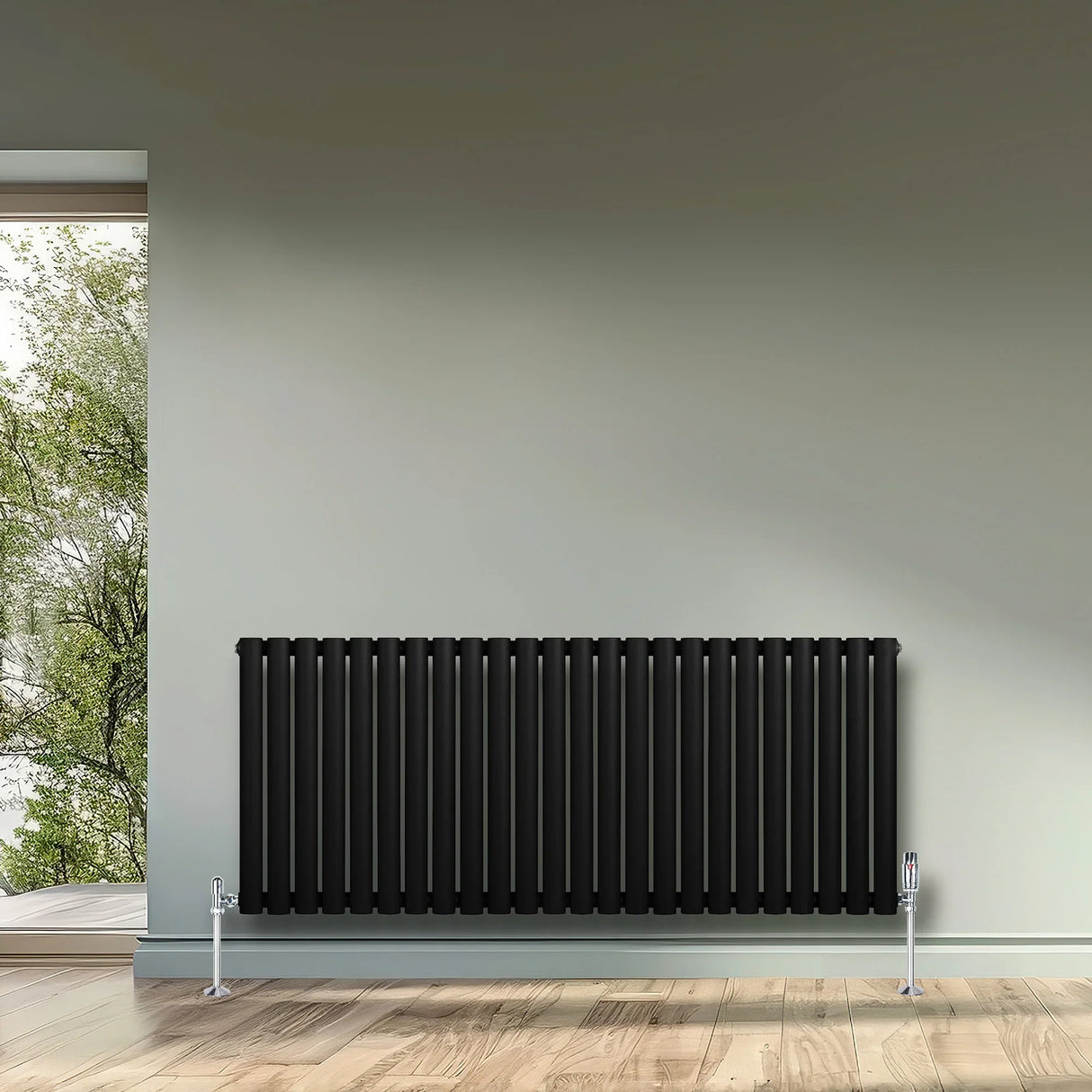 Sleek black oval single column radiator, 600 x 1440mm, mounted on a wall with a modern interior and natural light streaming in