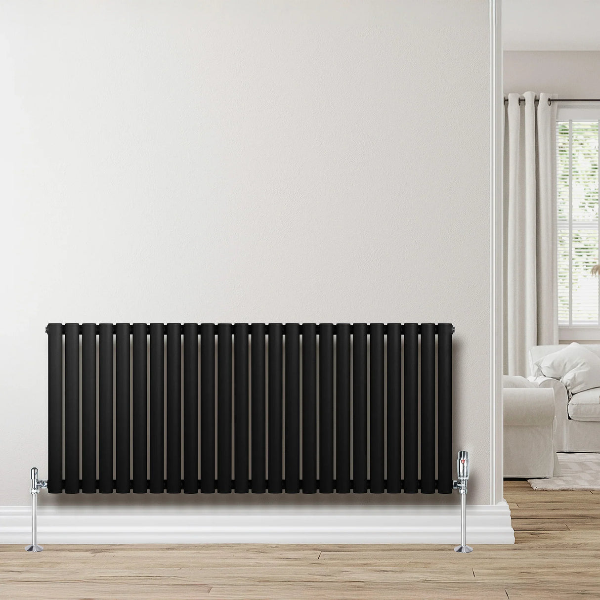 Sleek black oval single column radiator, 600 x 1440mm, mounted on a light wall, complementing a modern interior with wooden flooring