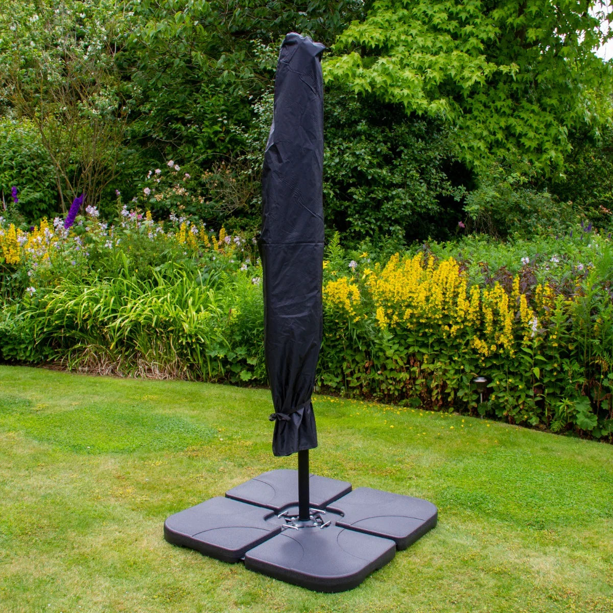 Green 3m LED cantilever parasol with a protective cover, set on a sturdy plain base, surrounded by lush garden greenery