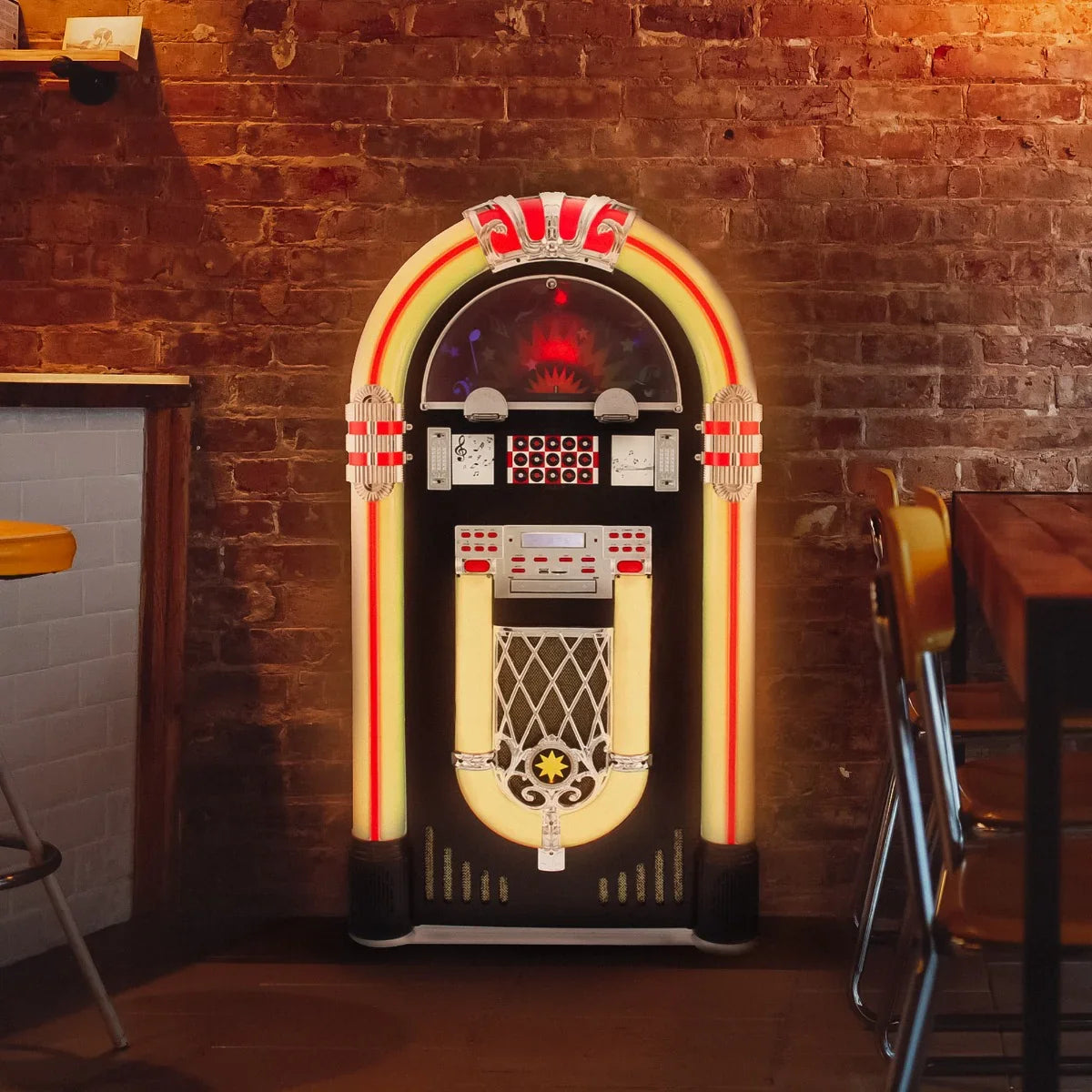 Retro jukebox vinyl record player with vibrant red and yellow accents, featuring a classic design and illuminated controls, set against a rustic brick wall