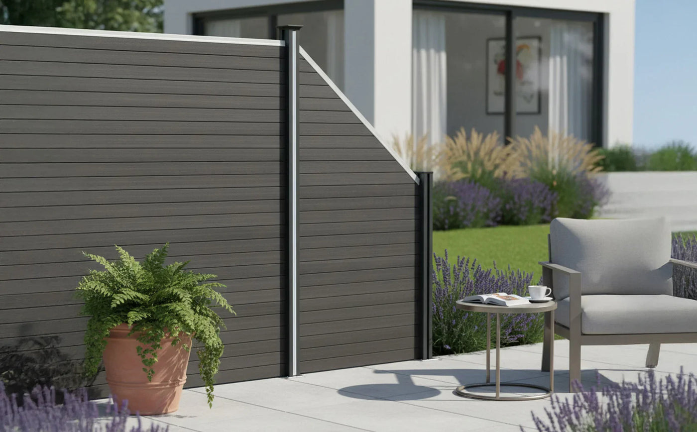 Modern outdoor patio featuring a sleek gray fence, potted fern, and a stylish chair beside a round table with a coffee cup
