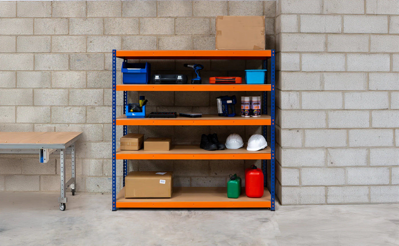 Bright orange metal shelving unit against a gray brick wall, displaying tools, safety gear, and storage boxes for an organized workspace
