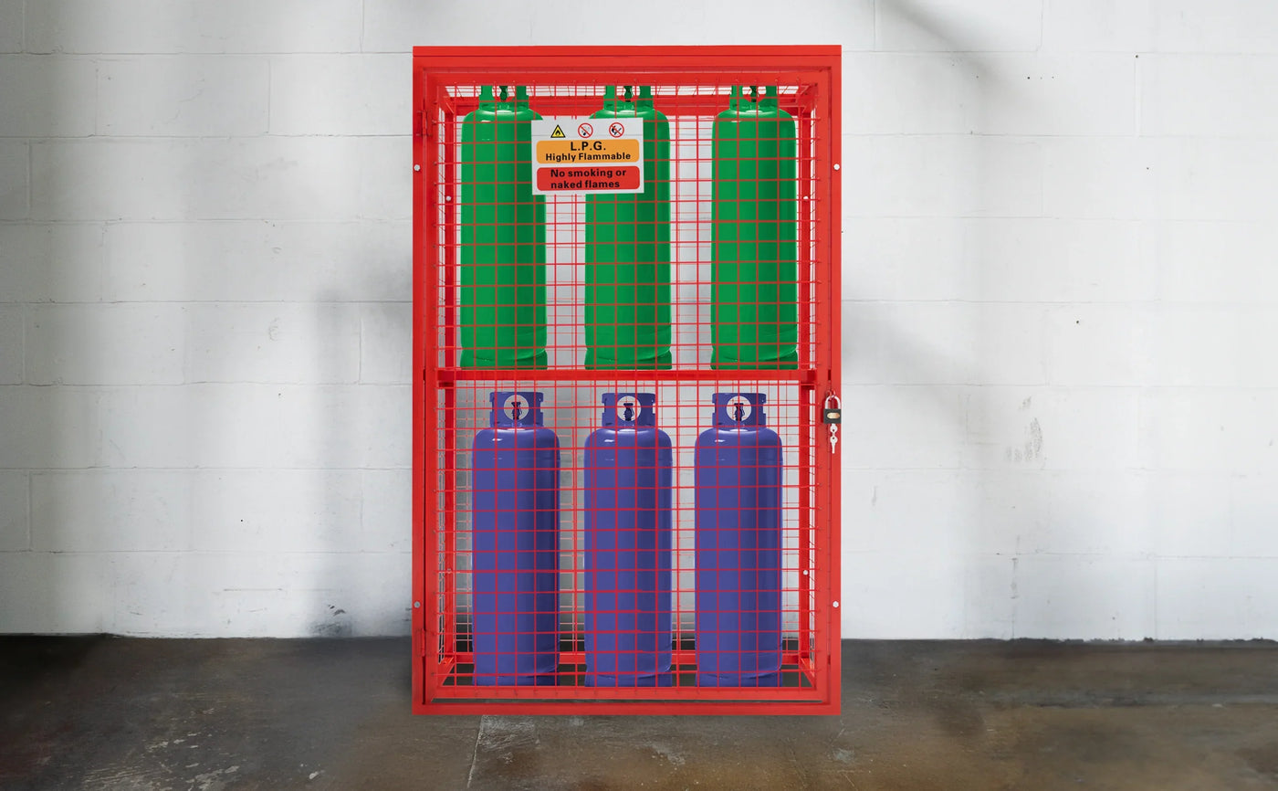 Four gas cylinders in a bright red wire mesh cage, featuring green and blue tanks, labeled for safety and storage compliance