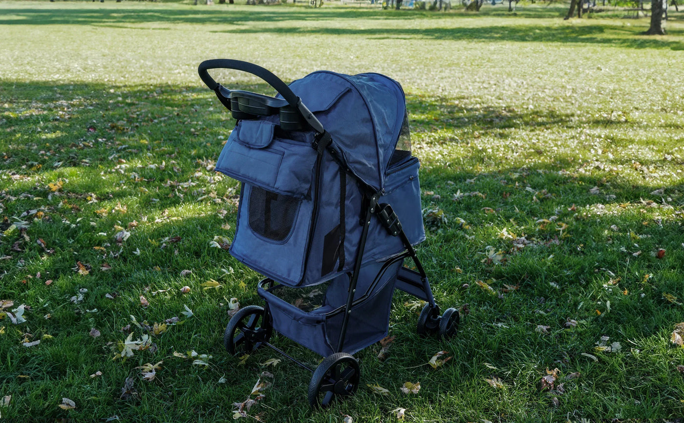 Navy blue stroller with a spacious canopy, storage pockets, and sturdy wheels, set on a grassy field with fallen leaves