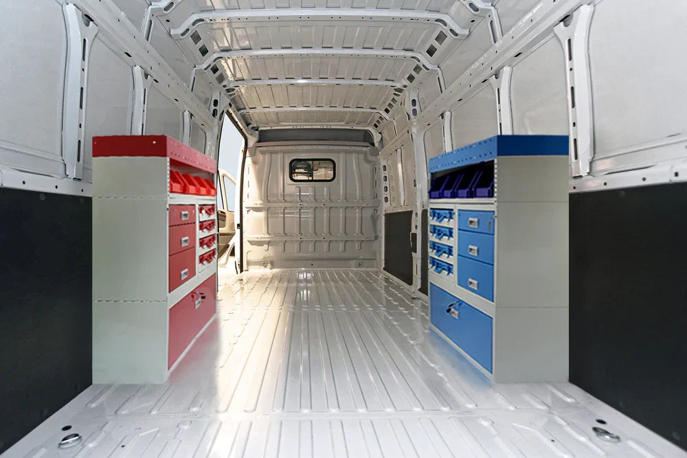 Interior of a van featuring red and blue tool cabinets, with a clean, white metal finish and spacious, empty cargo area