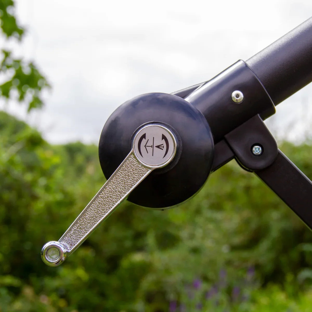 Close-up of the grey cantilever parasol's adjustable crank mechanism, showcasing its sleek design and durable materials