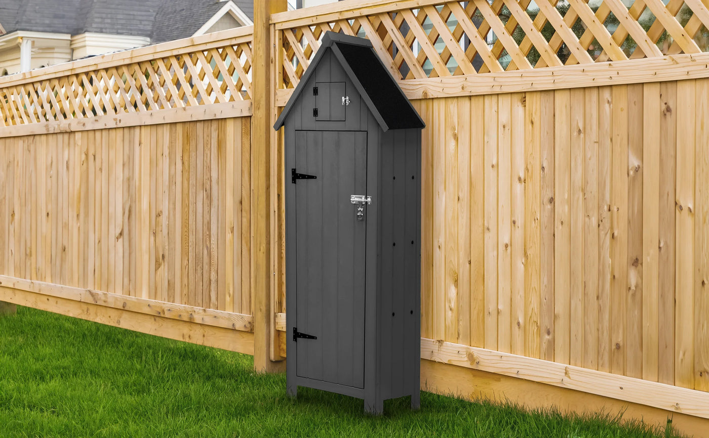 Stylish black wooden storage shed with a peaked roof, set against a wooden fence and green grass, perfect for outdoor organization