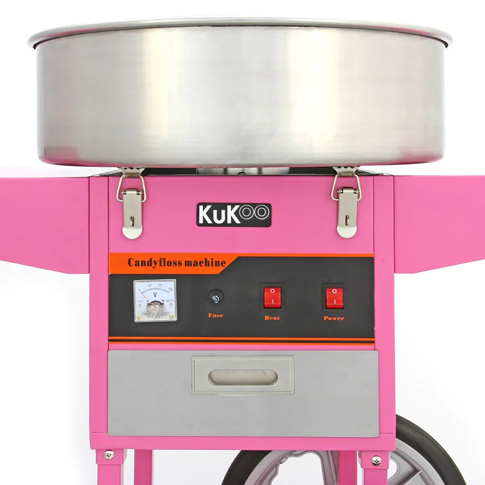 Bright pink KuKoo candy floss machine with stainless steel bowl, control panel featuring power and heat switches, and a sleek cart design