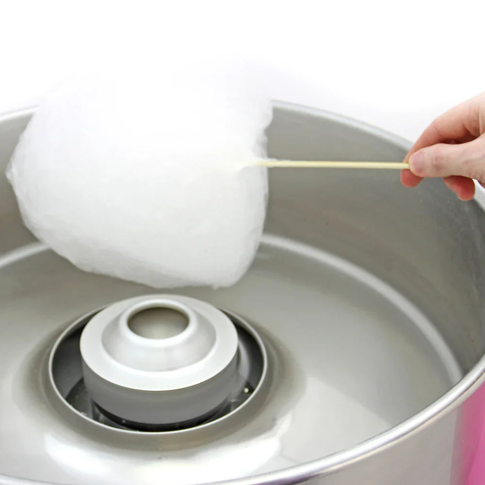 Fluffy white cotton candy being pulled from a silver KuKoo candy floss machine, showcasing its shiny metal bowl and spinning center