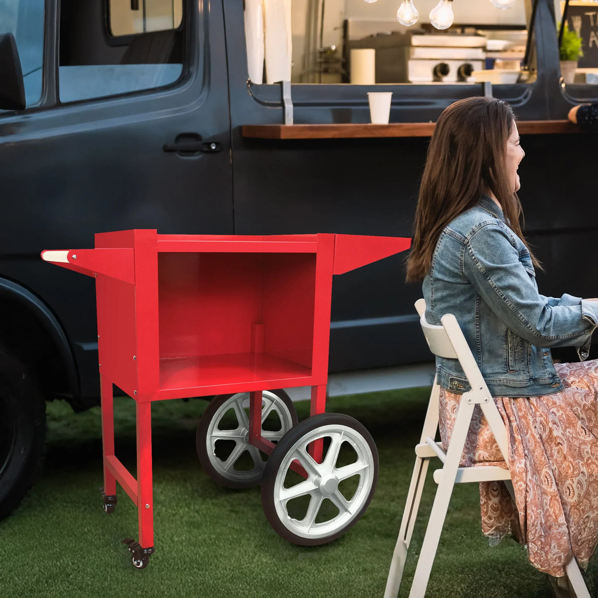 Bright red KuKoo popcorn machine cart with silver wheels, set against a food truck backdrop, perfect for outdoor events