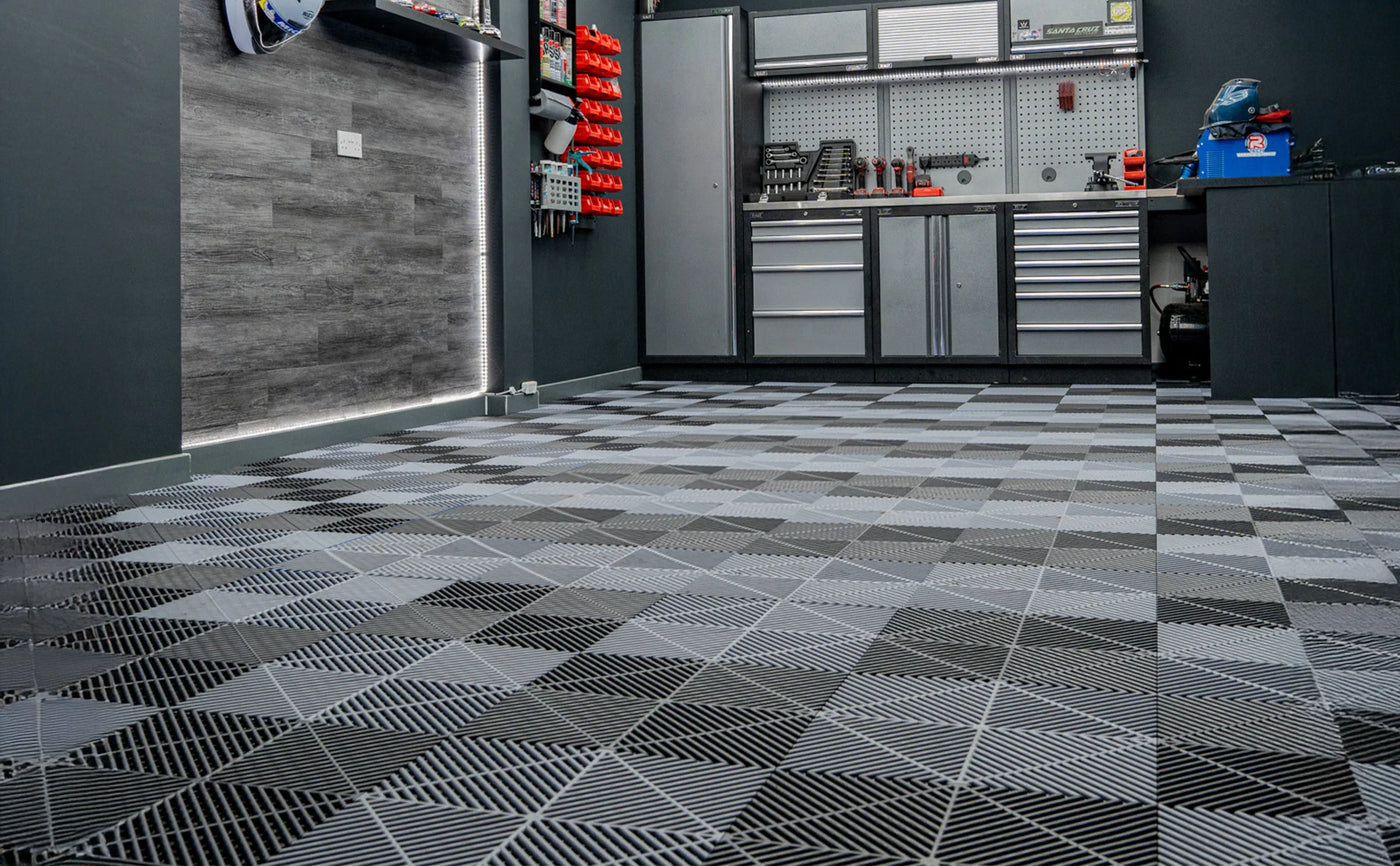 Stylish garage interior featuring a black and gray checkered floor, sleek tool storage, and modern lighting for an organized workspace