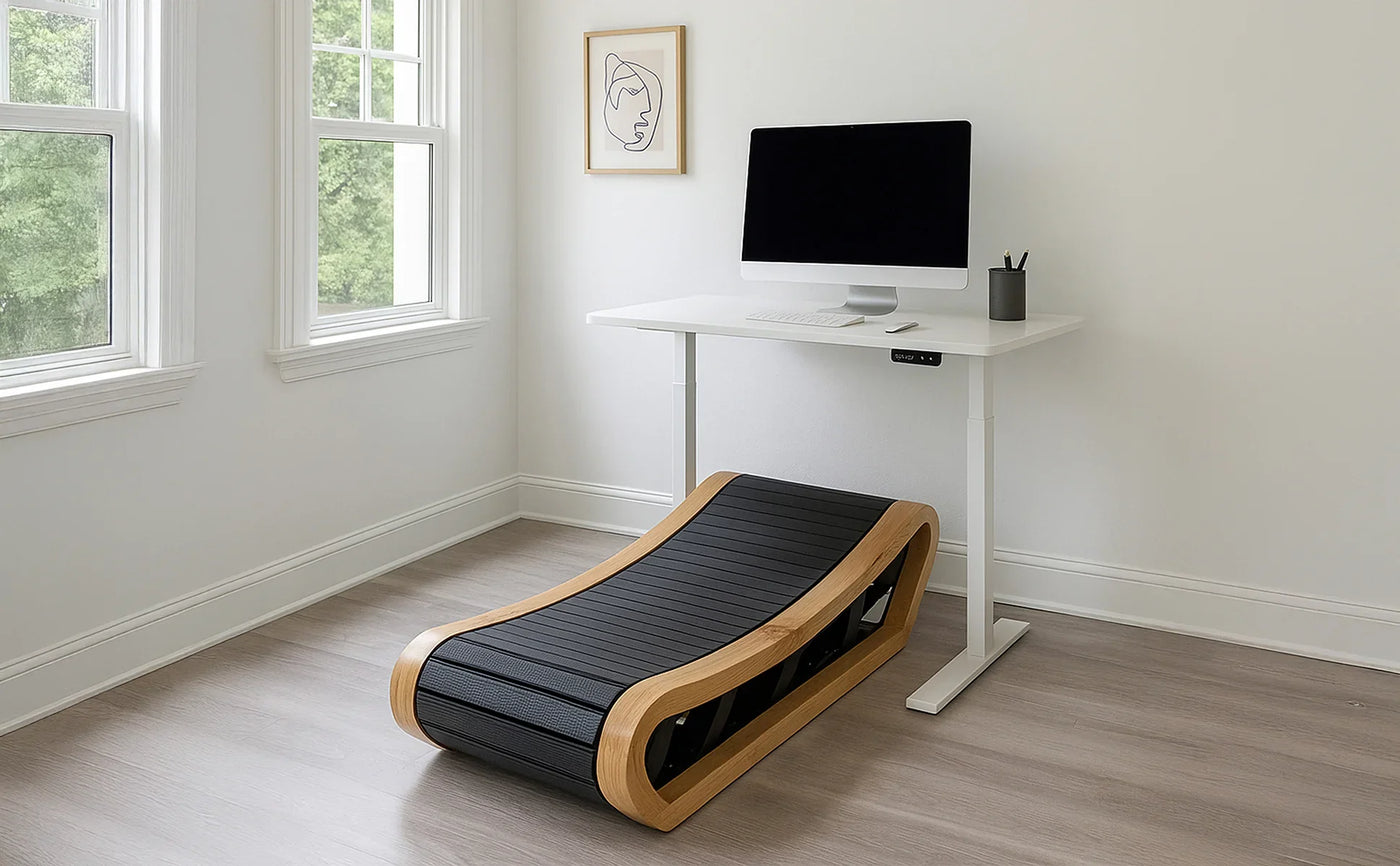 Modern home office featuring a sleek standing desk, a black treadmill with a wooden frame, and a computer setup by a window