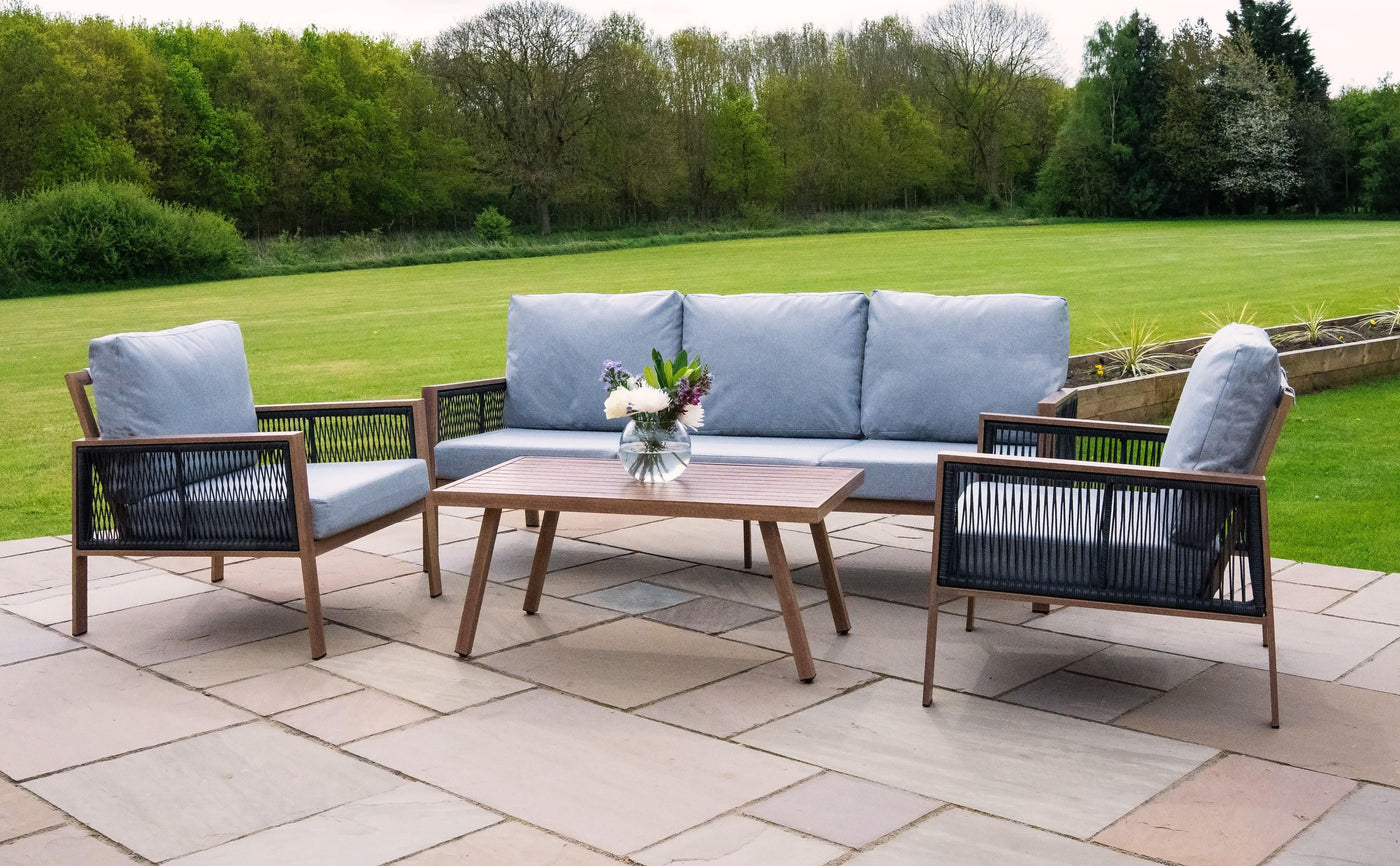 Stylish outdoor seating set featuring a gray cushioned sofa and chairs with wooden frames, complemented by a wooden coffee table