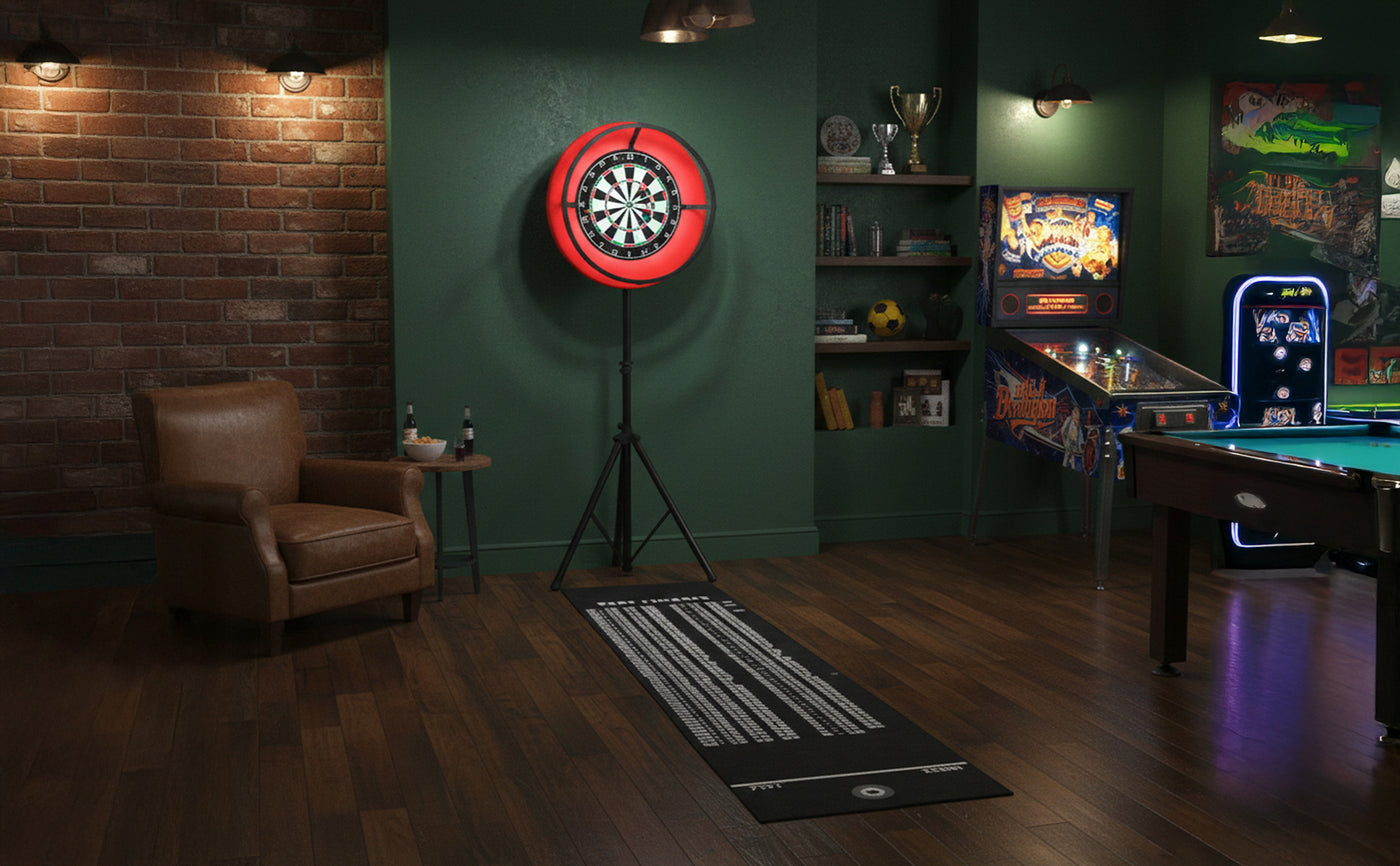 Cozy game room featuring a red dartboard, vintage pinball machine, green walls, wooden flooring, and a brown leather armchair