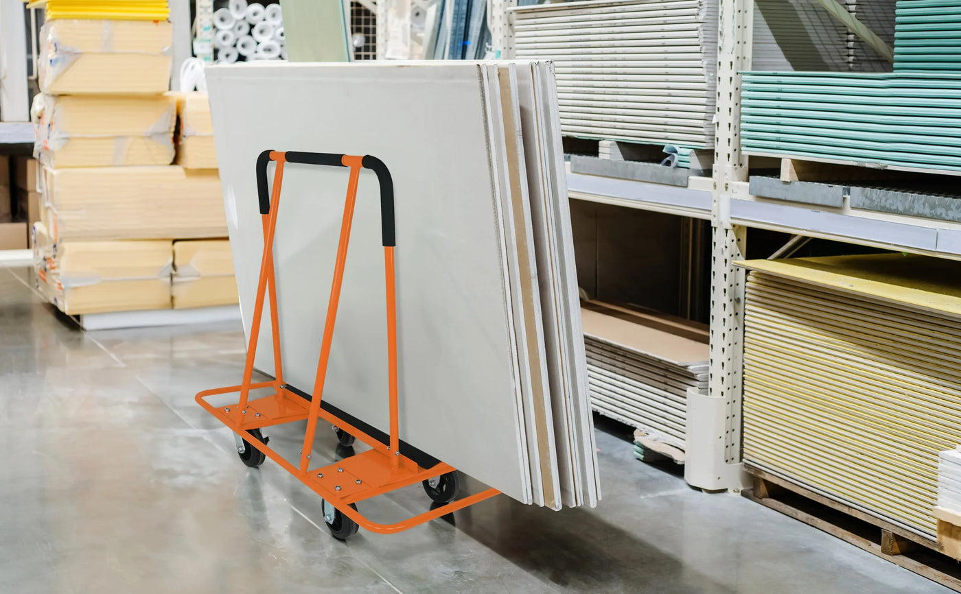 A sturdy orange cart loaded with large white panels, positioned on a shiny concrete floor in a well-organized warehouse aisle