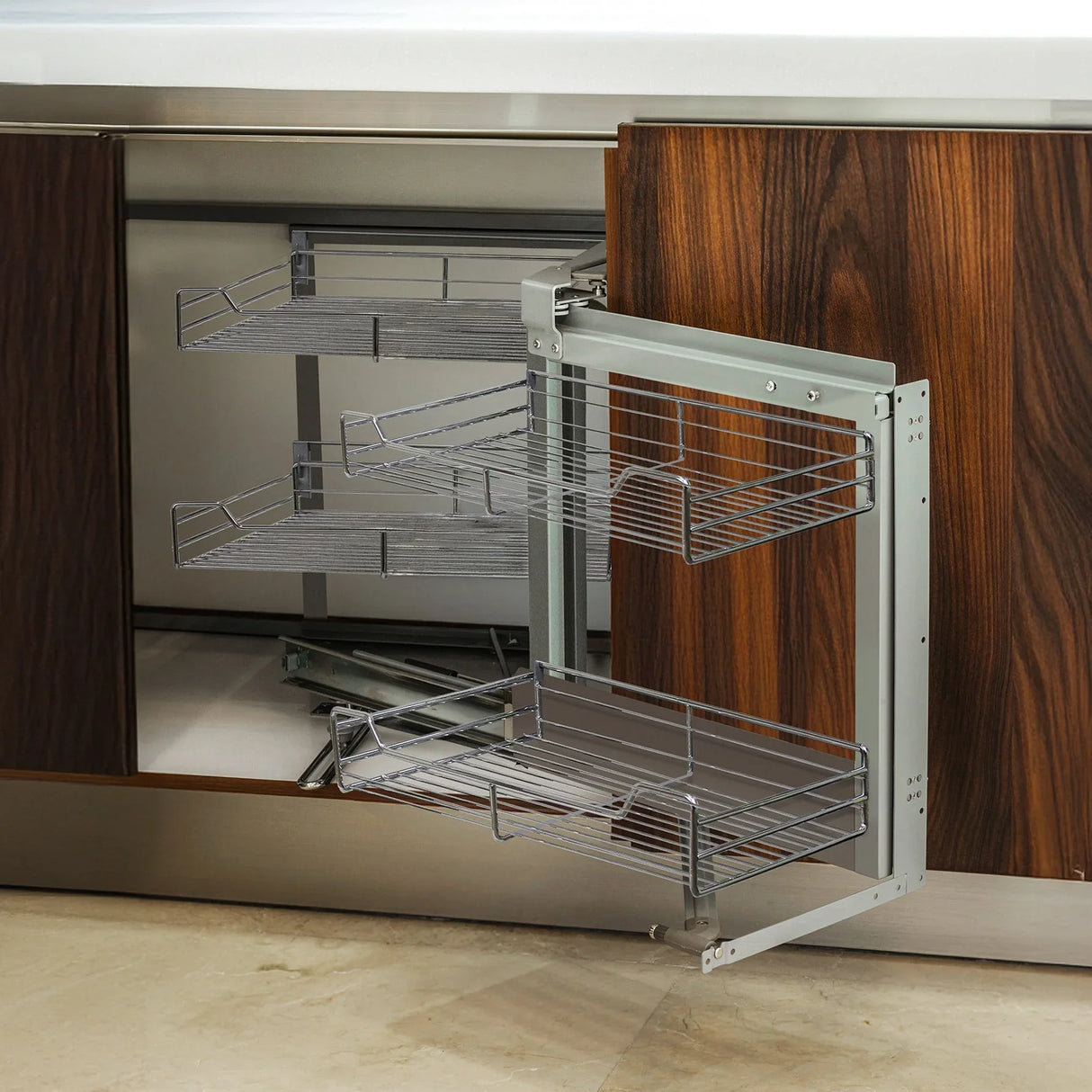 Corner kitchen cupboard pull-out drawers in sleek silver metal with three wire baskets, set against rich wood cabinetry