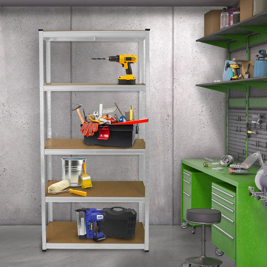 Metal shelving unit with tools, a drill, gloves, and a bucket on wooden shelves, set against a concrete wall and green workbench