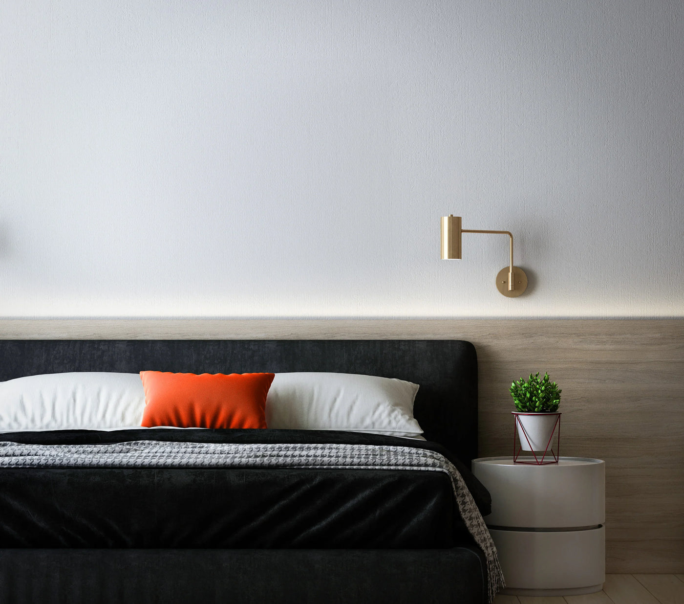 Modern bedroom featuring a black upholstered bed, white linens, an orange accent pillow, and stylish gold wall sconces with a potted plant