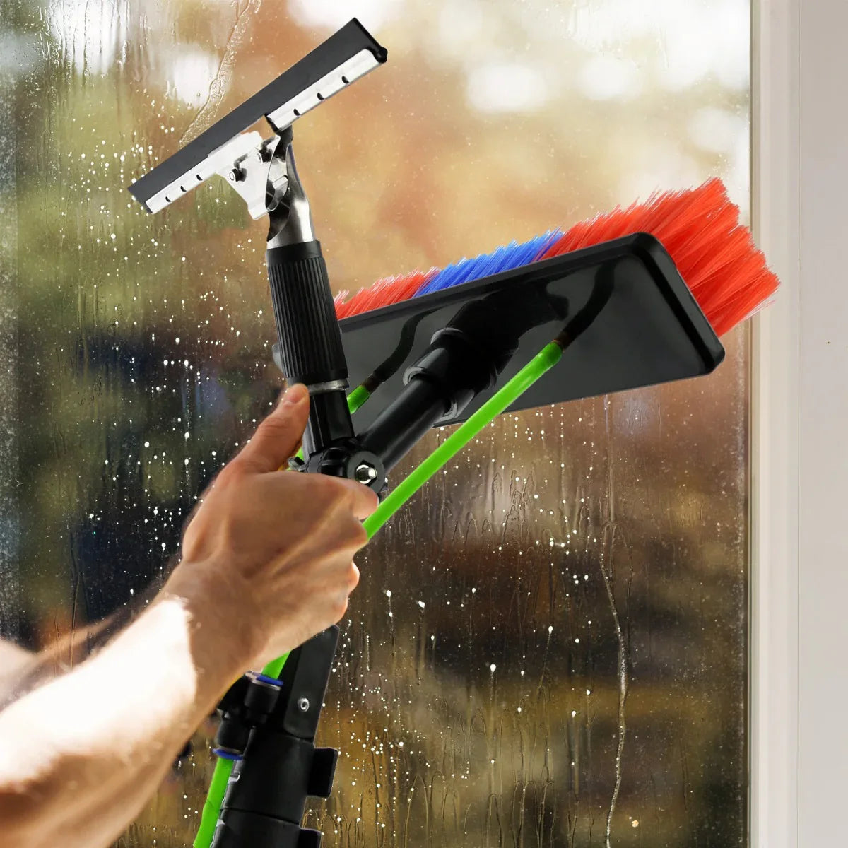 30ft water fed window cleaning pole with a squeegee and brush, featuring vibrant red and blue bristles, effectively cleaning a window
