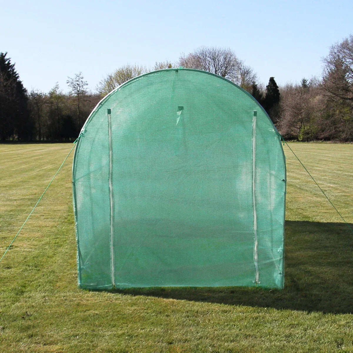 Green polytunnel measuring 2.5m x 2m, featuring a rounded top and mesh fabric, set on a grassy field with trees in the background